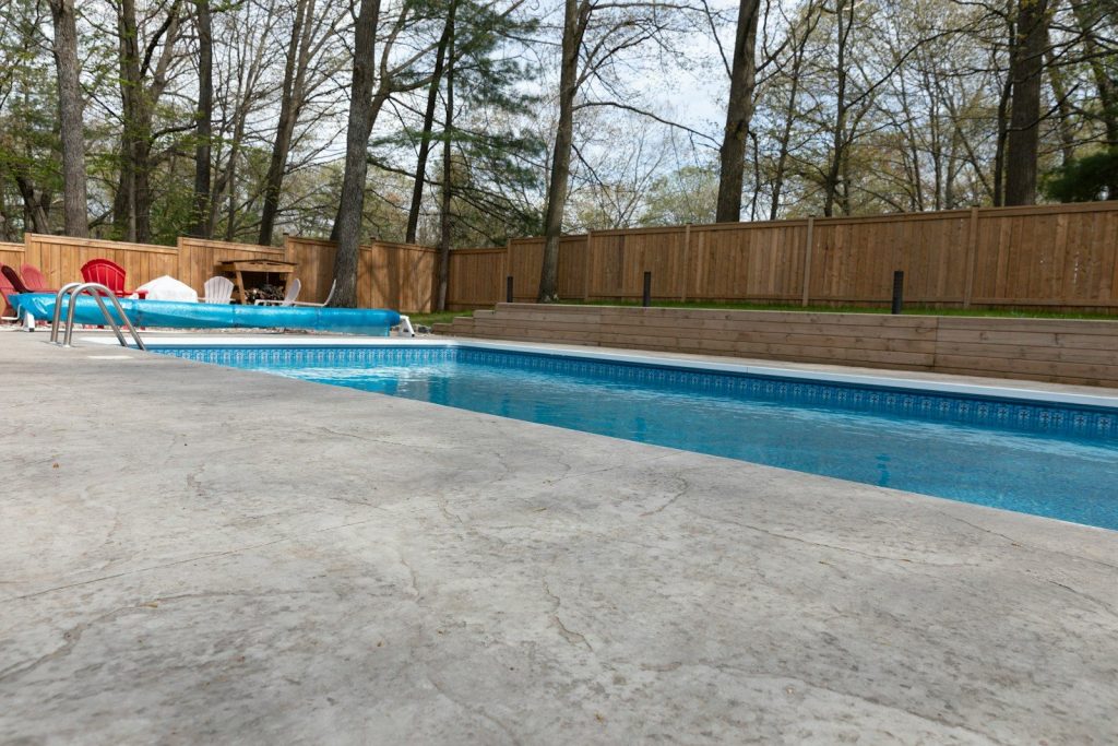A swimming pool sits in a backyard.