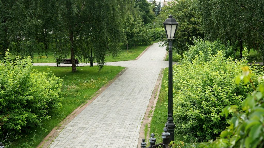 A paved path winds through a lush green park.