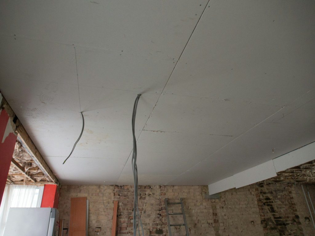 a room with a ladder and a brick wall