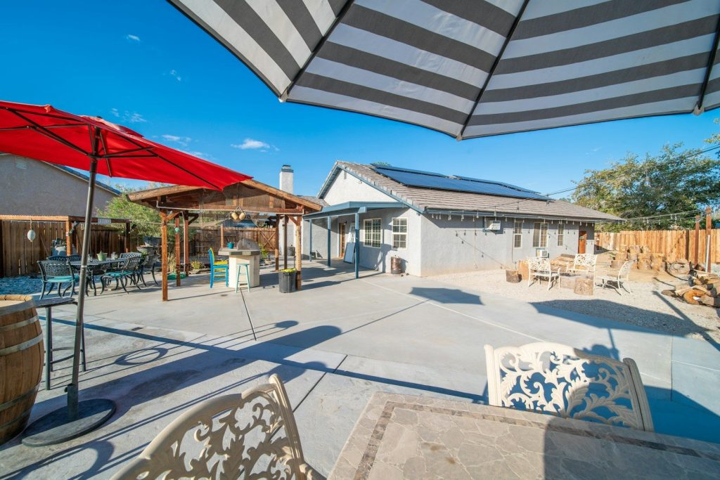 a patio with a table, chairs, and umbrellas